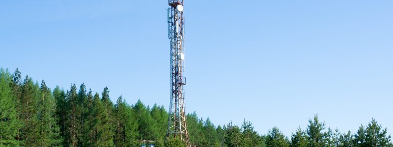 Cellular repeater tower on blue sky background. Spring landscape.
